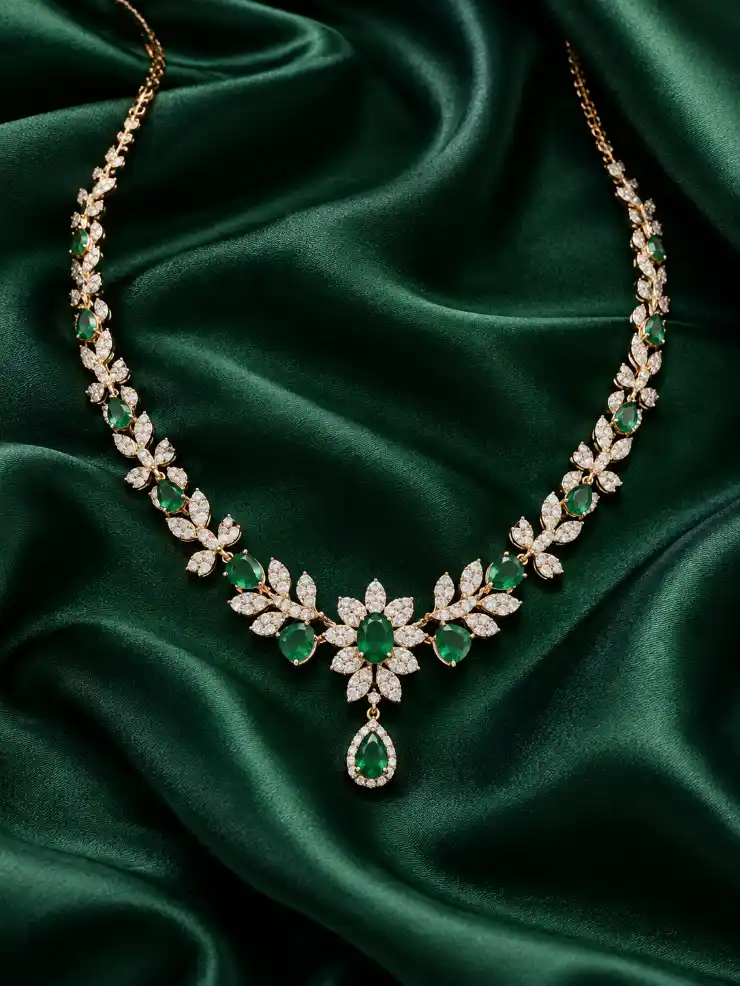 Emerald gemstone necklace displayed on deep green satin fabric