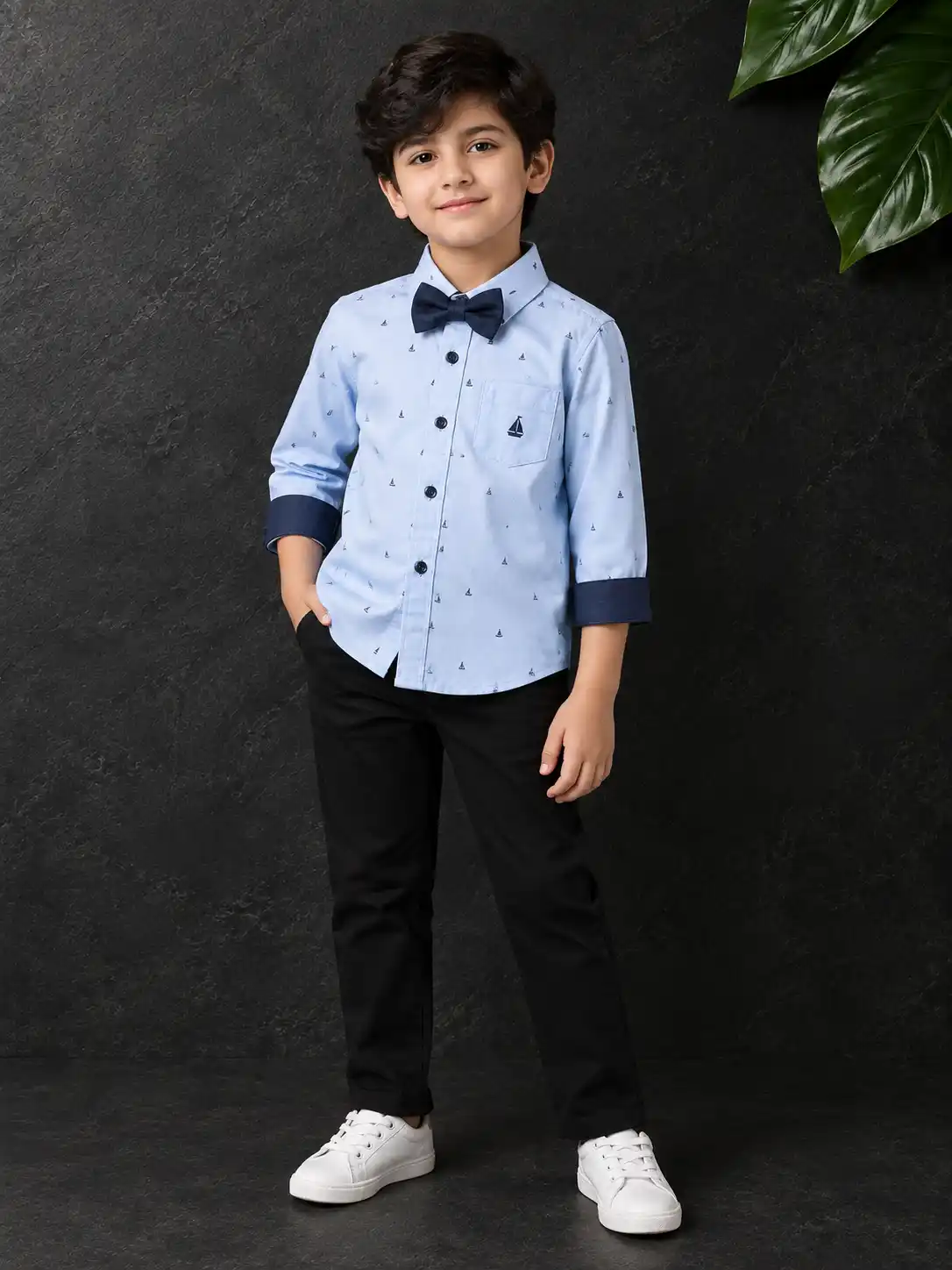 Child model wearing a clothing product in a dark luxury studio setting with soft lighting and realistic commercial fashion styling.