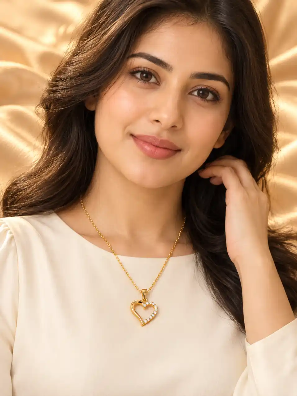 AI female model wearing a gold heart pendant necklace over an elegant cream top with a warm champagne satin background.